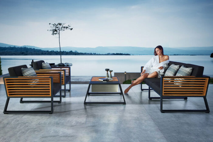 Salon de jardin haut de gamme aluminium bois de la collection New-York, comprenant: Un canapé 3 places, deux fauteuils et une table basse. Matériaux: Aluminium noir, bois de teck, Tissu en olefine de couleur anthracite.