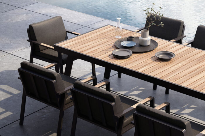 Zoom sur le plateau en teck de la grande table en aluminium noir Nofi.